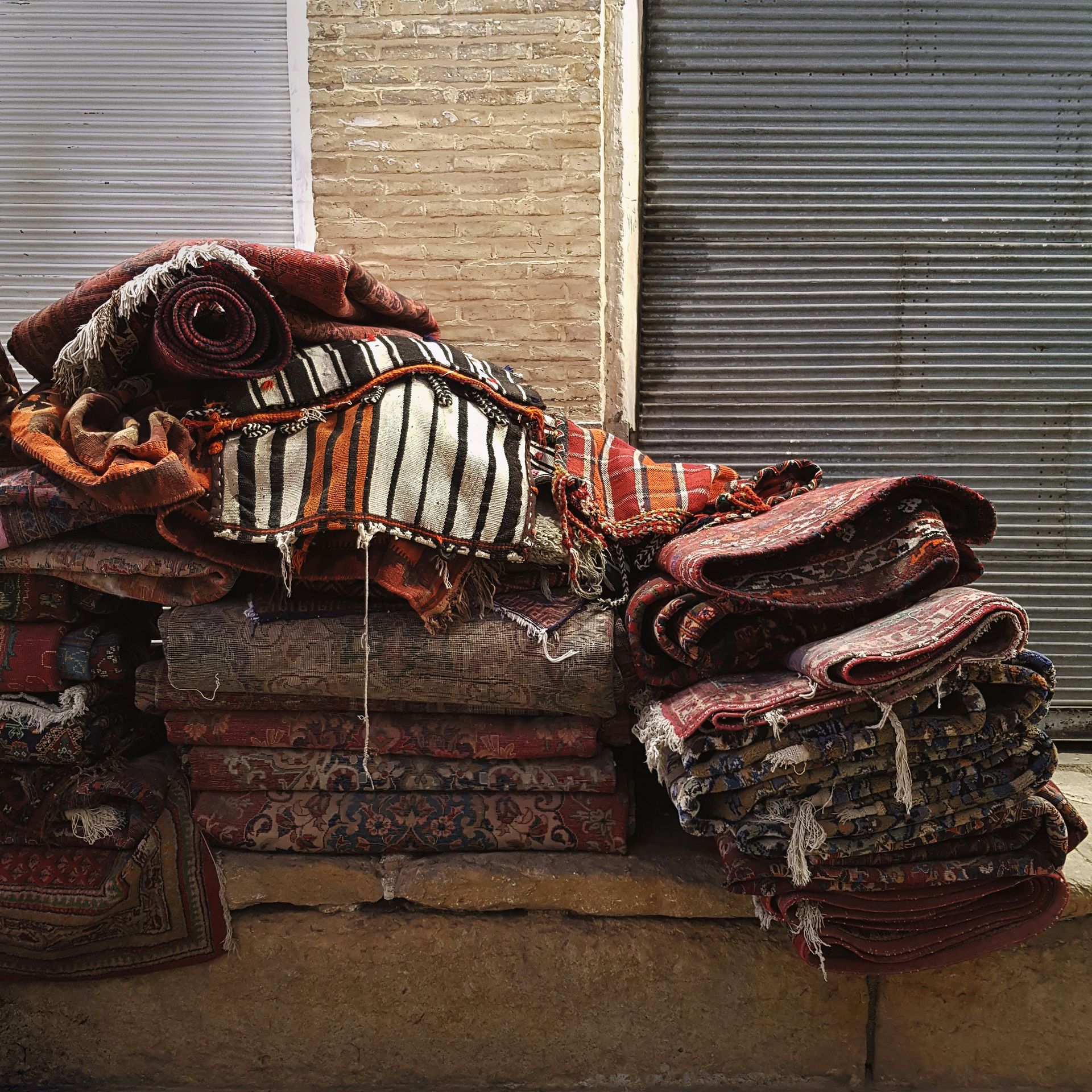 a pile of rugs sitting on the side of a building